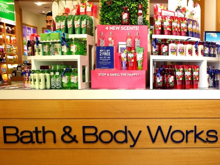 A Bath and Body Works store display showcasing various scented body care products, including lotions and sprays, with a promotional sign highlighting new scents and special offers.