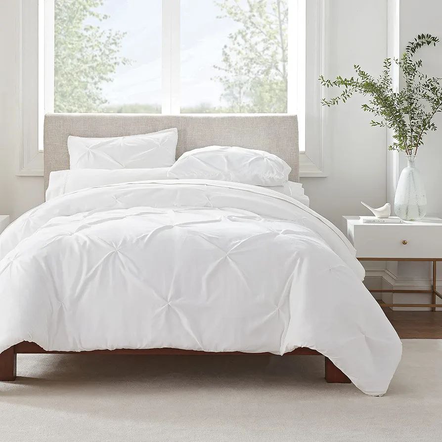 Bright and airy bedroom featuring a crisp white duvet with matching pillows on a neutral bed frame, complemented by minimalistic decor. This duvet is currently on sale.