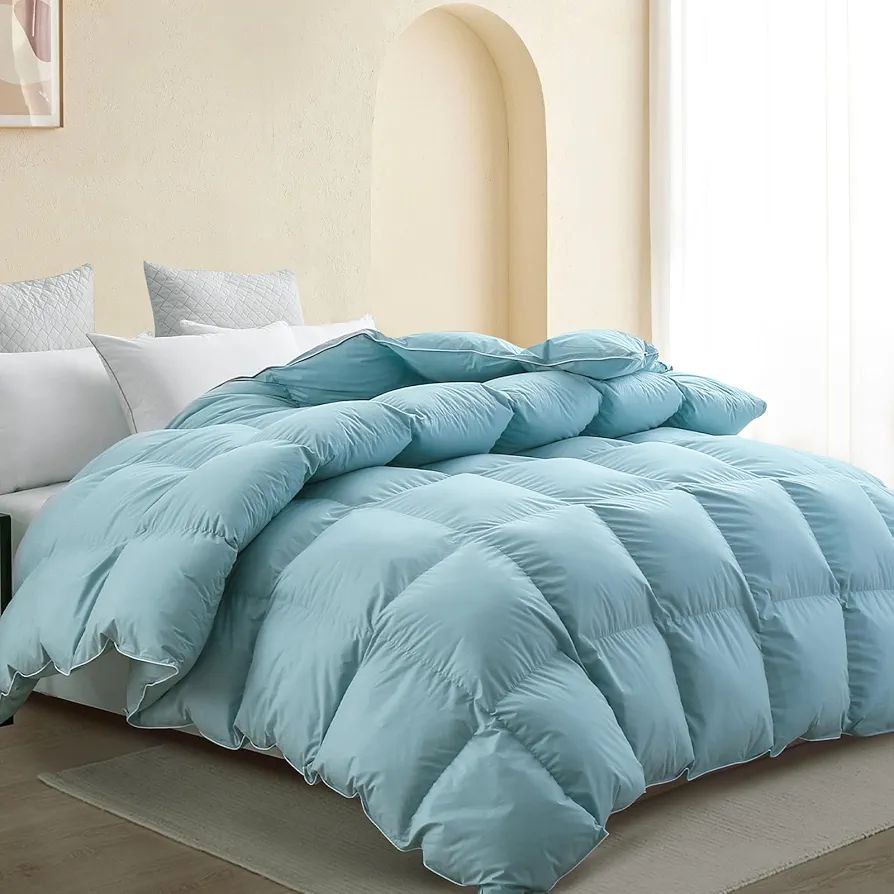 Cozy bedroom with a light blue puffy duvet and matching pillows, creating a soft and inviting atmosphere. A perfect duvet for comfort and style.