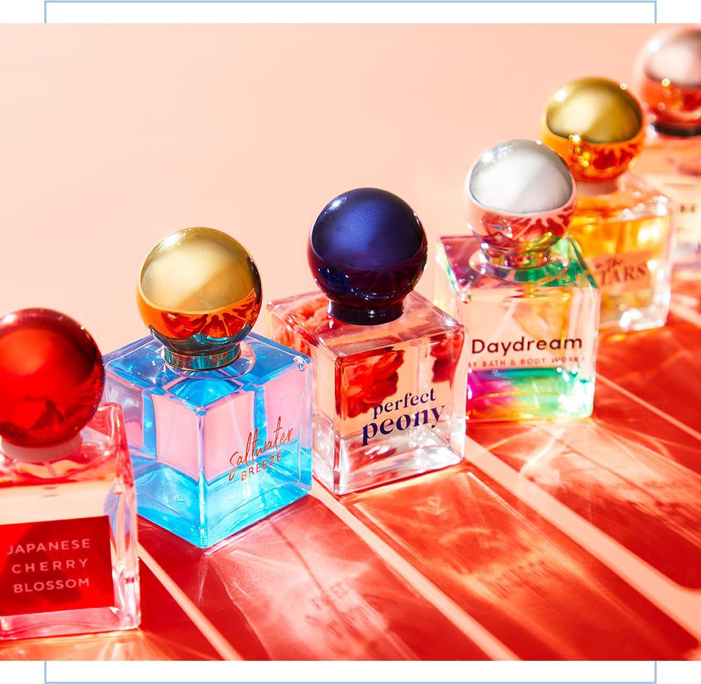 Collection of perfumes, featuring scents like Japanese Cherry Blossom, Saltwater Breeze, Perfect Peony, and Daydream, in colorful bottles with metallic caps.