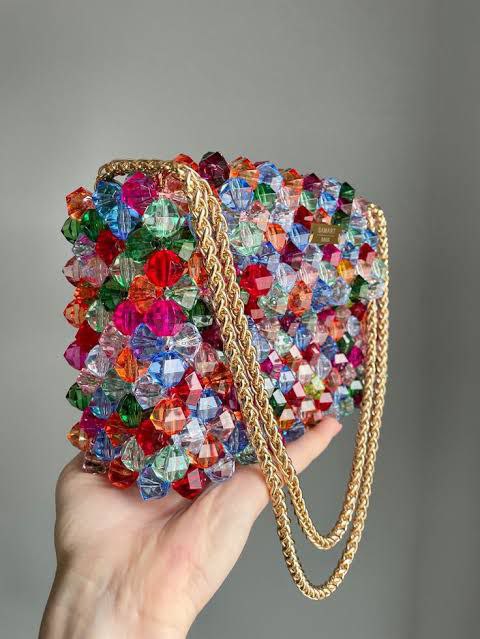 Colorful crystal beaded bag with a vibrant mix of red, green, blue, and clear beads, featuring a gold chain strap for a bold and eye-catching accessory.