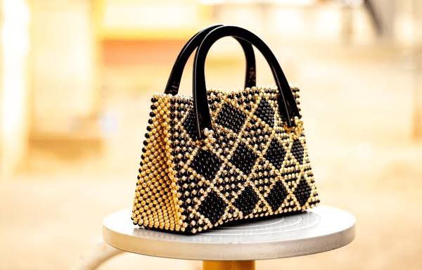 Elegant beaded bag with a black and gold diamond pattern and sleek black handles, designed for a stylish and sophisticated look.